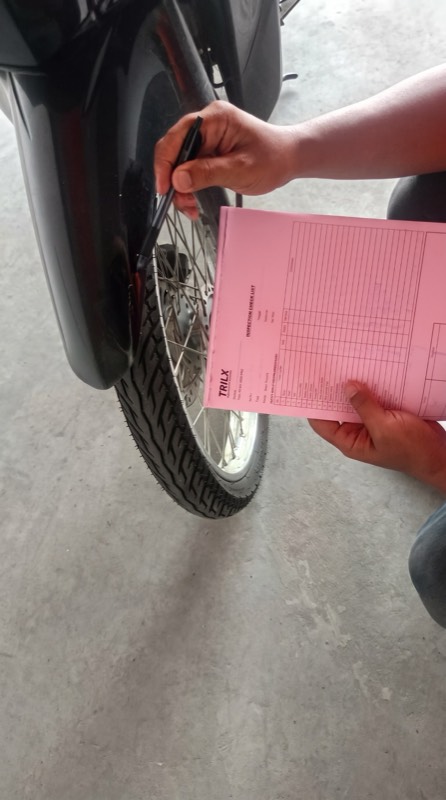 Petugas TRILX mengisi checklist inspeksi kondisi motor sebelum pengiriman